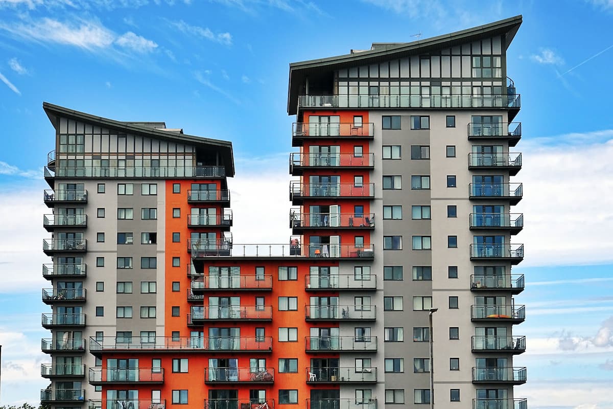 Photo of a gray, orange, and red apartment building. 