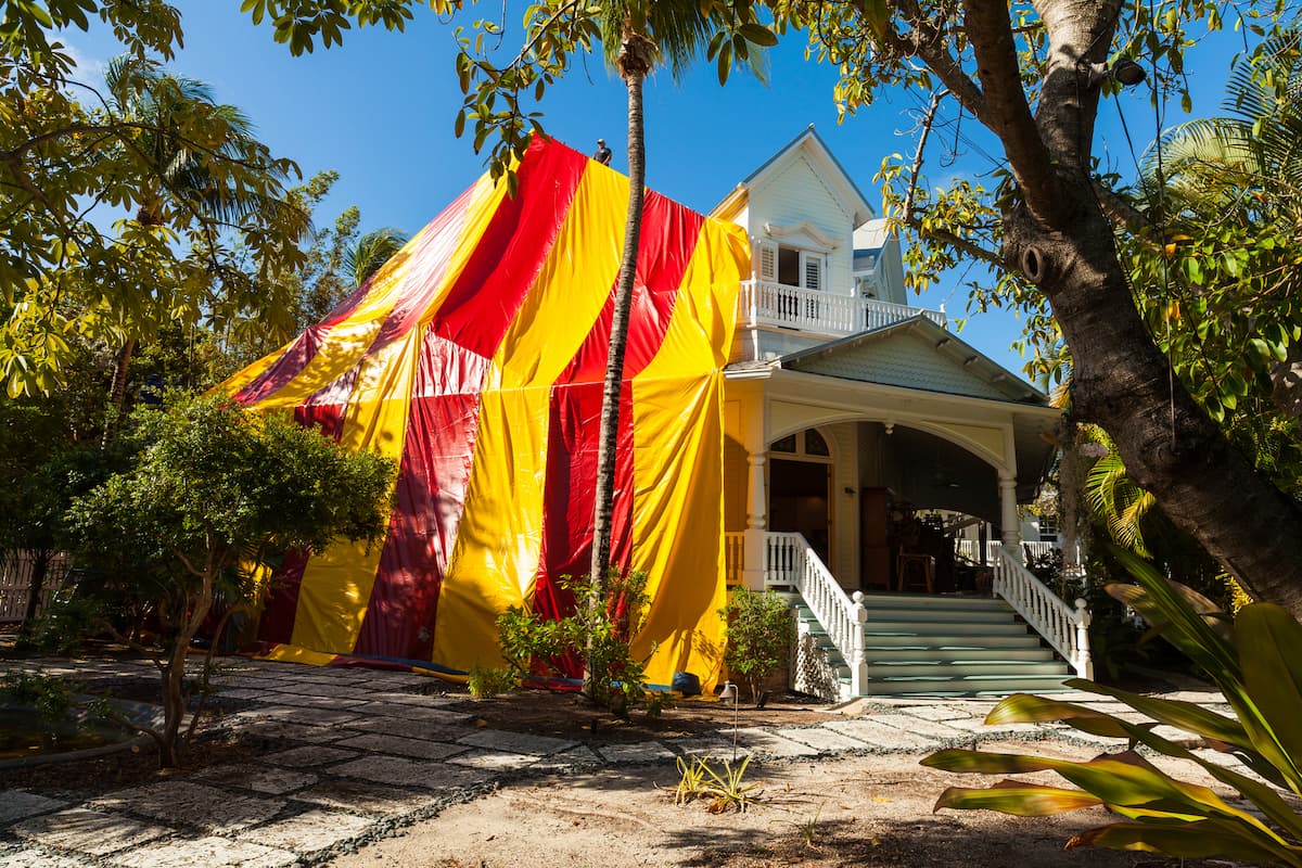 Vintage wooden house covered by a tent for termite treatment.