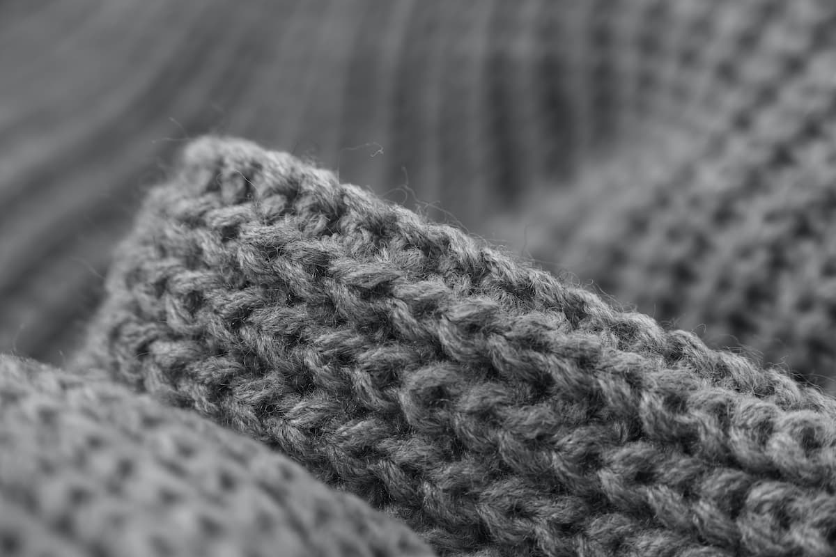Close-up photo of a gray knitted cardigan. 